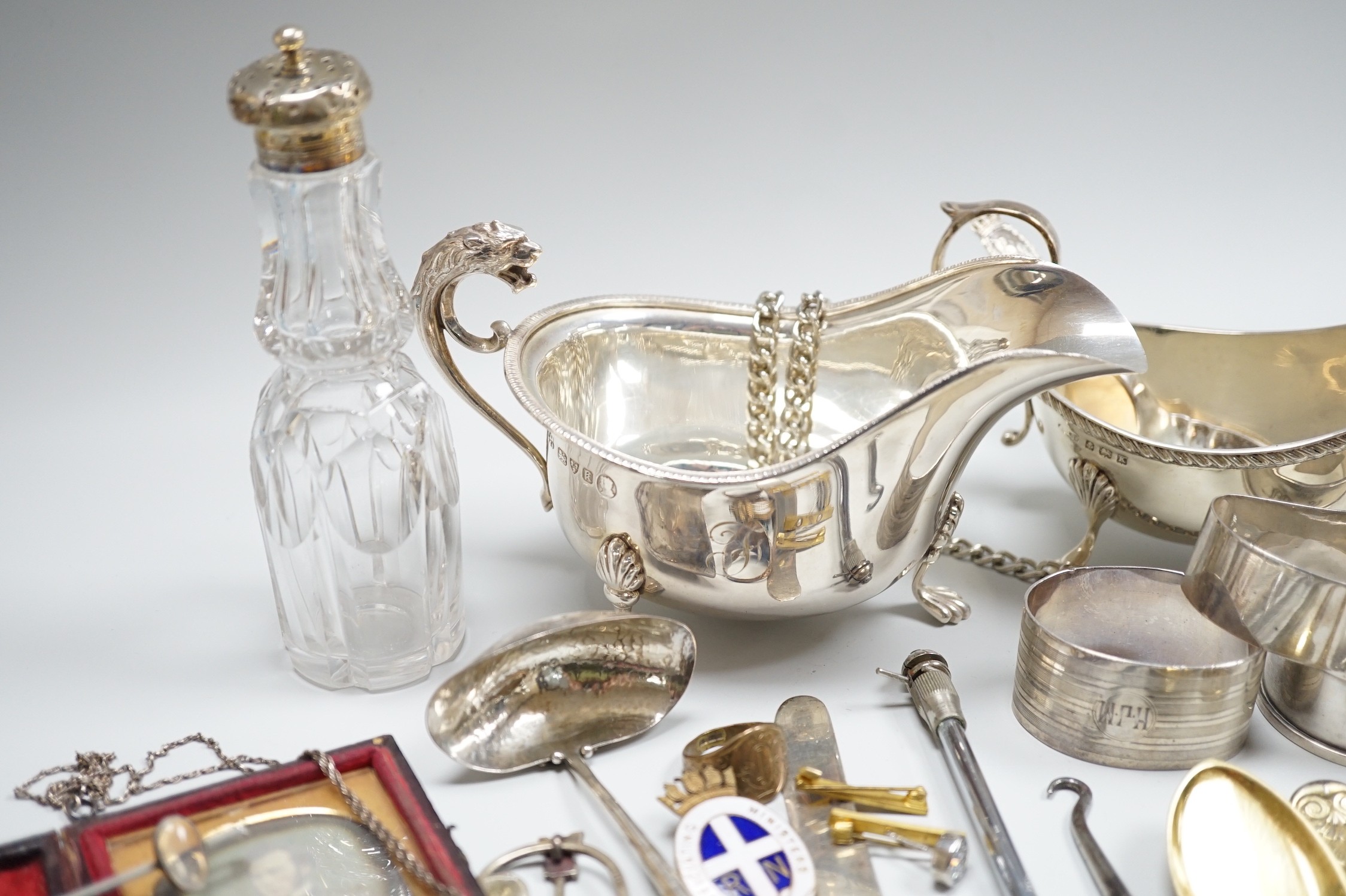 Sundry small silver including two sauceboats, napkin rings, mounted glass condiment bottle, pepperette, pair of silver gilt preserve spoons, minor flatware including white metal, a 1920's Georg Jensen silver cream ladle,